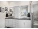 Bright bathroom featuring double sinks, white cabinets, and a modern glass-enclosed shower at 8815 S Tibet Ct, Aurora, CO 80016