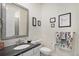 Well-lit bathroom boasts a modern vanity with a gray countertop and decorative wall art at 8815 S Tibet Ct, Aurora, CO 80016