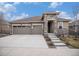Inviting two-story home with a three-car garage, stone accents, and well-manicured lawn at 8815 S Tibet Ct, Aurora, CO 80016
