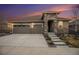 Inviting home exterior with a stone facade, a three-car garage, and a well-maintained front yard at sunset at 8815 S Tibet Ct, Aurora, CO 80016