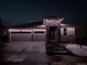 Charming home with a stone accent and festive outdoor lights illuminating the home's front exterior at night at 8815 S Tibet Ct, Aurora, CO 80016