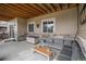 Cozy outdoor patio area with stone accents, comfortable seating, and a stylish coffee table on a concrete slab at 8815 S Tibet Ct, Aurora, CO 80016