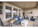 Relaxing covered patio featuring comfortable seating, a colorful rug, and ample natural light from large windows at 8815 S Tibet Ct, Aurora, CO 80016