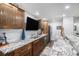Beautiful wet bar with granite countertops, a modern sink, wood cabinetry, and ample lighting at 8815 S Tibet Ct, Aurora, CO 80016