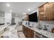 Stylish wet bar with a TV, bar seating, elegant wood cabinets, and modern design elements at 8815 S Tibet Ct, Aurora, CO 80016