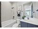 Cozy bathroom with modern vanity, tub, shower with white subway tile and black hardware at 9006 E 60Th Ave, Denver, CO 80238
