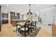 Bright dining area with modern light fixture, open shelving, and hardwood floors leading to the staircase at 9006 E 60Th Ave, Denver, CO 80238