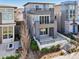 A modern home showcasing a multi-tiered patio design with grey and stone siding at 9006 E 60Th Ave, Denver, CO 80238