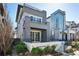 A modern home showcasing a multi-tiered patio design with grey and stone siding at 9006 E 60Th Ave, Denver, CO 80238