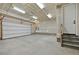 Spacious two-car garage with a bright interior, featuring a large overhead door and access stairs at 9006 E 60Th Ave, Denver, CO 80238