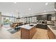 Open kitchen featuring a center island, stainless steel appliances, and hardwood floors open to the dining and living areas at 9006 E 60Th Ave, Denver, CO 80238