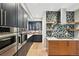 Sleek kitchen featuring stainless steel appliances, modern cabinets, stylish backsplash, and hardwood floors at 9006 E 60Th Ave, Denver, CO 80238