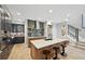 Stylish kitchen with a large island featuring seating, stainless steel appliances, modern backsplash, and hardwood floors at 9006 E 60Th Ave, Denver, CO 80238