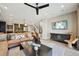 Spacious living room features modern decor, a comfortable leather sofa, and a sleek ceiling fan at 9006 E 60Th Ave, Denver, CO 80238
