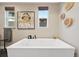 Close-up of a freestanding tub with modern fixtures, and natural light from a window at 9006 E 60Th Ave, Denver, CO 80238