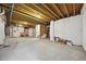 Expansive unfinished basement with exposed wooden ceiling beams, ready for customization and storage at 9006 E 60Th Ave, Denver, CO 80238