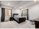 Cozy bedroom with large windows, neutral carpet, and a comfortable dark wood bed at 15205 W Iliff Ave, Lakewood, CO 80228