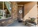 Charming entryway features a wood door with stone accents, a window, and a cozy side table at 15205 W Iliff Ave, Lakewood, CO 80228