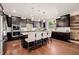 Modern kitchen featuring dark cabinets, stainless appliances, a large island, and hardwood floors at 15205 W Iliff Ave, Lakewood, CO 80228