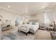 A beautiful main bedroom with a tray ceiling, ensuite bath, and a charming sitting area at 15205 W Iliff Ave, Lakewood, CO 80228