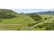 Scenic aerial view showcasing rolling hills and a winding road at 13 Pinyon Pine Rd, Littleton, CO 80127