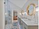Well-lit bathroom with double vanities, a glass shower, and a view into the bedroom at 13 Pinyon Pine Rd, Littleton, CO 80127