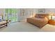 Serene bedroom features neutral carpeting, a wicker bed frame, and access to a private balcony at 13 Pinyon Pine Rd, Littleton, CO 80127