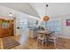 Bright dining area with wood table, white chairs, and access to the kitchen at 13 Pinyon Pine Rd, Littleton, CO 80127