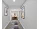 Long hallway adorned with framed artwork leading to various rooms, illuminated by stylish lighting at 13 Pinyon Pine Rd, Littleton, CO 80127