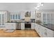 Well-lit kitchen with white cabinets, stainless steel appliances, and hardwood flooring at 13 Pinyon Pine Rd, Littleton, CO 80127