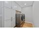 Bright laundry room featuring modern side-by-side washer and dryer with ample cabinet space at 13 Pinyon Pine Rd, Littleton, CO 80127