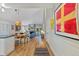 Open-concept dining and living area with a fireplace, wood floors, and large framed wall art at 13 Pinyon Pine Rd, Littleton, CO 80127