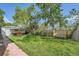 Spacious backyard featuring a lush green lawn, wooden fence, patio seating, and mature trees at 5127 Lowell Blvd, Denver, CO 80221