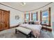 Cozy bedroom featuring natural light, wood trim, neutral carpet, and a comfortable seating area at 5127 Lowell Blvd, Denver, CO 80221