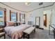 Well-lit bedroom with wood trim, neutral carpet, bench, and stylish lighting, showcasing comfort and style at 5127 Lowell Blvd, Denver, CO 80221
