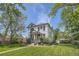 Beautiful home exterior with a manicured lawn, mature trees, and a quaint front porch at 5127 Lowell Blvd, Denver, CO 80221