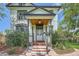 Charming front porch featuring wooden accents and decorative pillars, complemented by lush landscaping at 5127 Lowell Blvd, Denver, CO 80221