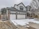 Two-story home with a three-car garage and mixed brick and siding exterior, set in a snow covered landscape at 18646 E Garden Pl, Aurora, CO 80015