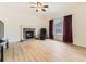 Cozy living room featuring a fireplace, large window with curtains, and sleek wood flooring at 18646 E Garden Pl, Aurora, CO 80015