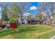 Well-manicured backyard features a playset, lush lawn and patio space for outdoor dining at 6918 E Easter Pl, Centennial, CO 80112