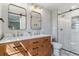 Bright bathroom featuring double sinks with a wood vanity and a glass-enclosed shower at 6918 E Easter Pl, Centennial, CO 80112