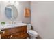 Chic half bath features a wood vanity, elegant fixtures, and modern design at 6918 E Easter Pl, Centennial, CO 80112