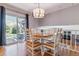 Bright dining area with hardwood floors, stylish chandelier, and sliding glass doors to the backyard at 6918 E Easter Pl, Centennial, CO 80112
