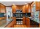The kitchen offers modern appliances, wood cabinets, and granite countertops, creating a functional cooking space at 6918 E Easter Pl, Centennial, CO 80112