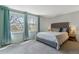 Serene main bedroom with large windows, plush carpeting, and a tufted headboard at 6918 E Easter Pl, Centennial, CO 80112