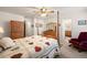 Well-lit bedroom with a four-poster bed, dresser, and view into the bathroom at 2085 Cactus Bloom Ct, Castle Rock, CO 80109