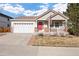 Charming single-Gathering home with a red front door, attached garage, and well-maintained front yard at 2085 Cactus Bloom Ct, Castle Rock, CO 80109