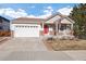 Inviting home featuring a front porch, two-car garage and manicured lawn at 2085 Cactus Bloom Ct, Castle Rock, CO 80109