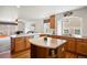 Well-lit kitchen with wooden cabinets, a central island, and a view into the cozy living area at 2085 Cactus Bloom Ct, Castle Rock, CO 80109
