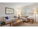 Comfortable living room featuring two sofas, a glass-topped coffee table, and ample natural light at 2085 Cactus Bloom Ct, Castle Rock, CO 80109